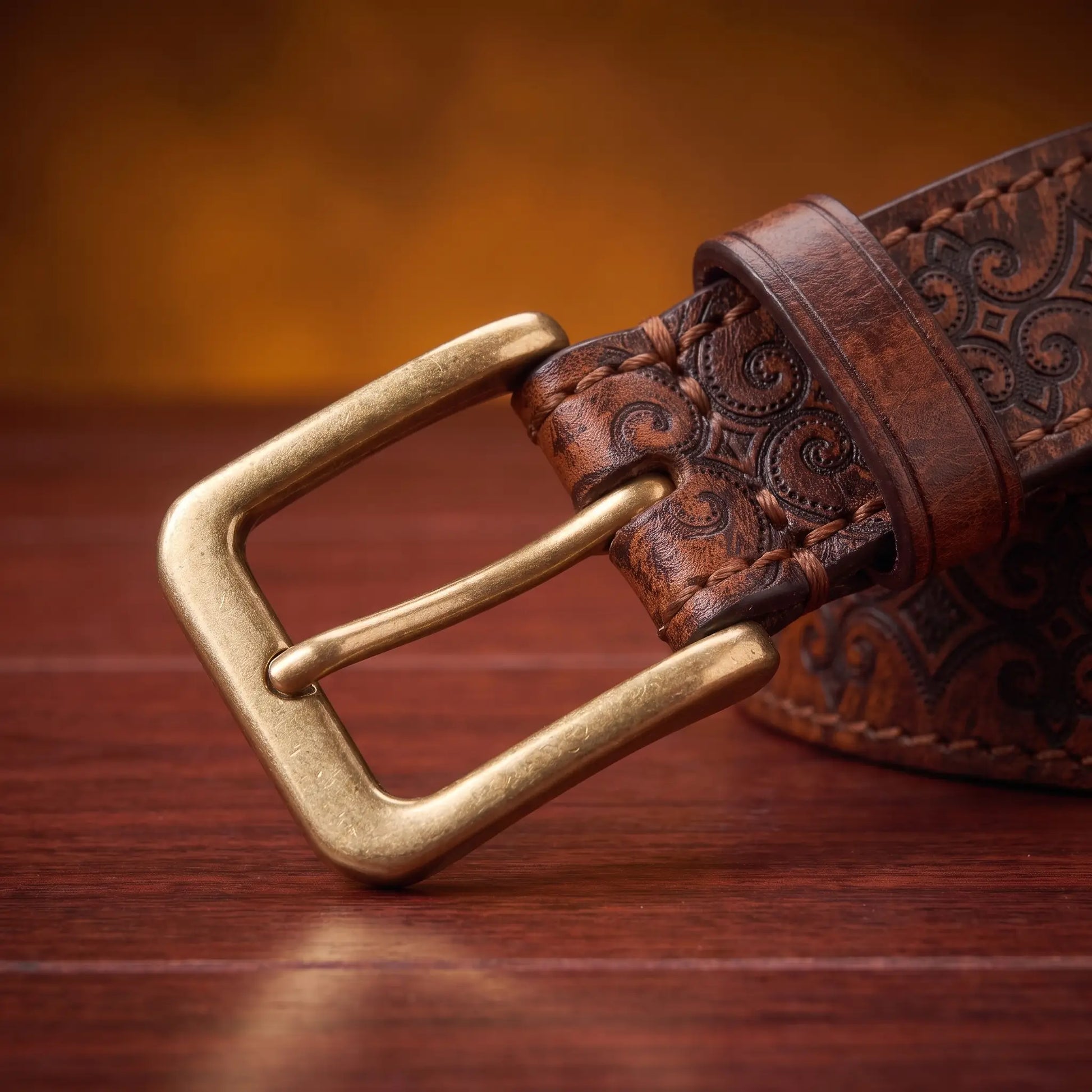 Close up of the antique brass prong buckle and leather keeper loop on the Tooled Pattern Belt