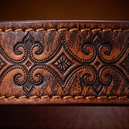 Macro close up of the carved scroll tooling and edge stitching on the Tooled Pattern Belt