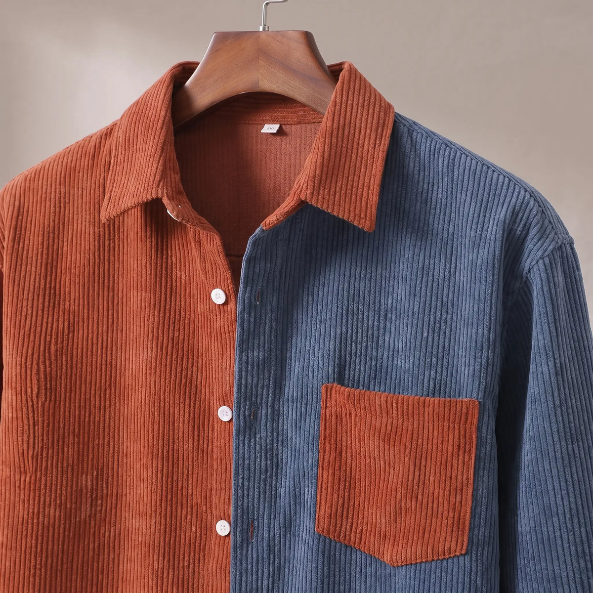 Close up of the collar, white button placket and contrast patch chest pocket on the rust and blue Two Tone Overshirt