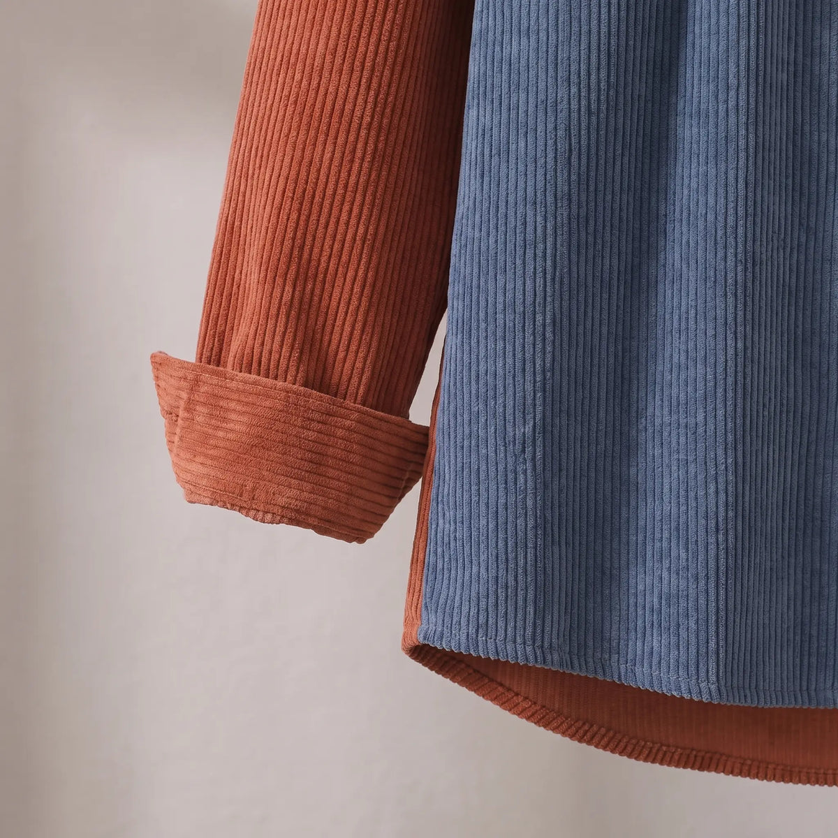 Close up of the turned back cuff and straight hem on the rust and blue Two Tone Overshirt