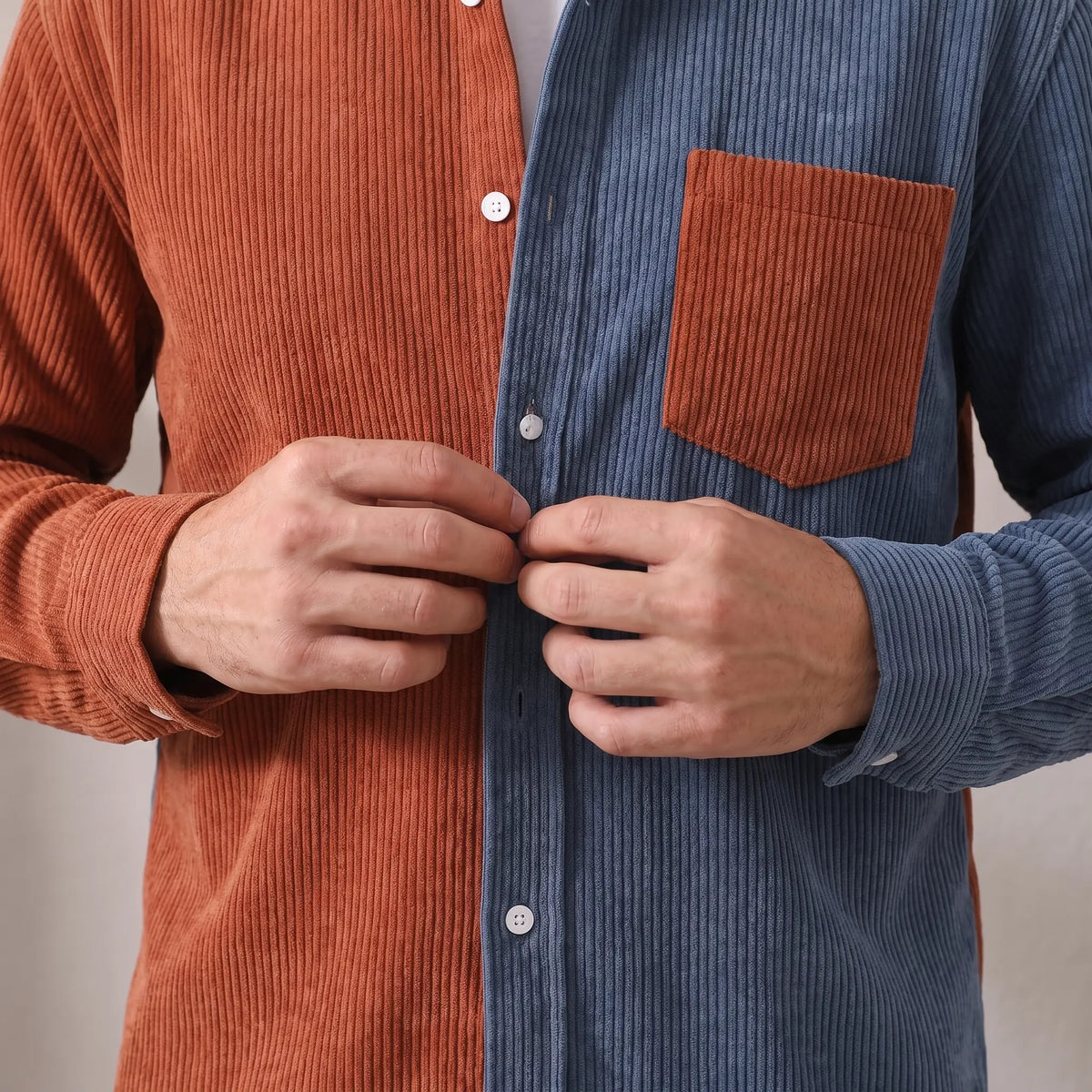 Man buttoning up the rust and blue Two Tone Overshirt corduroy overshirt