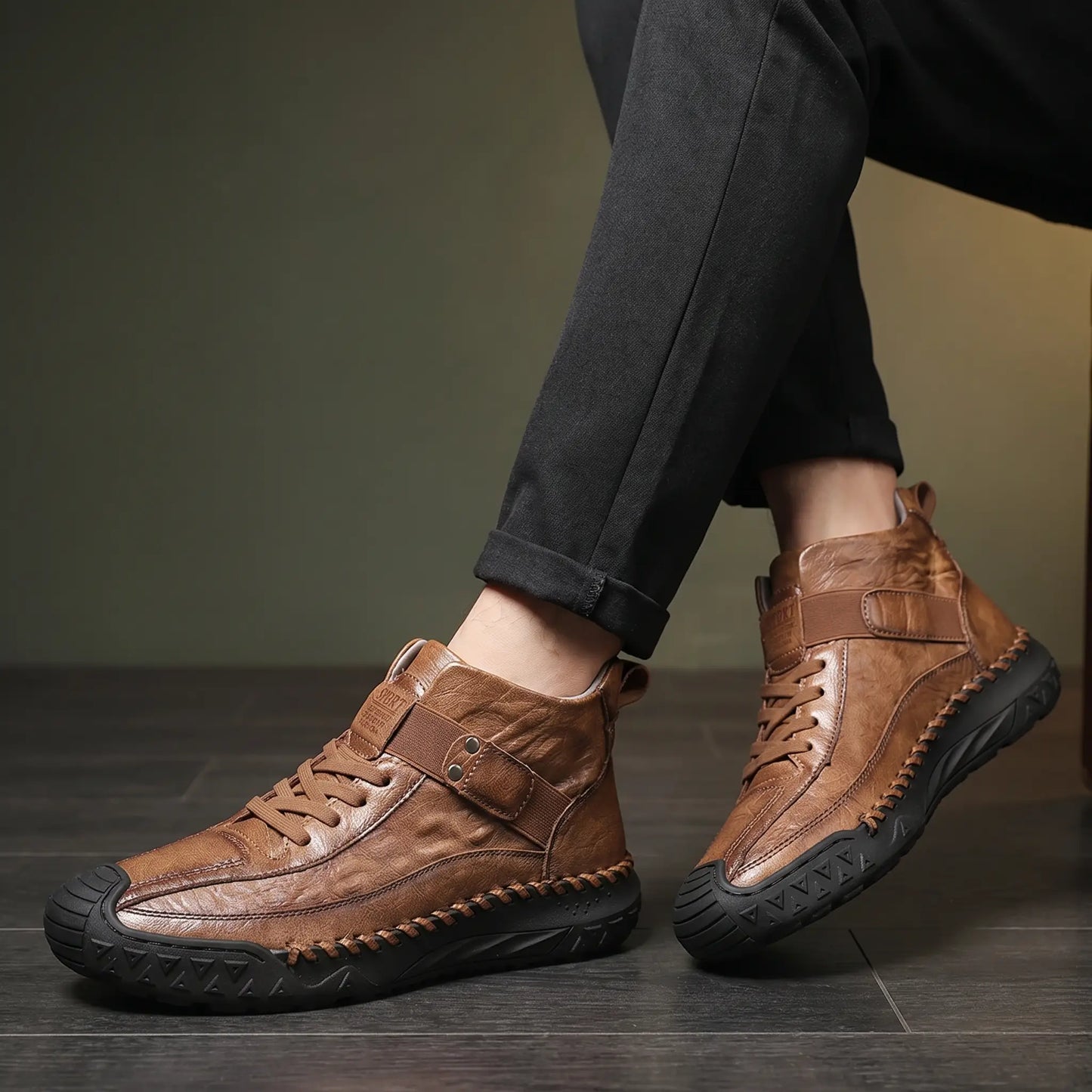 Boots worn with ankles crossed on a wooden floor