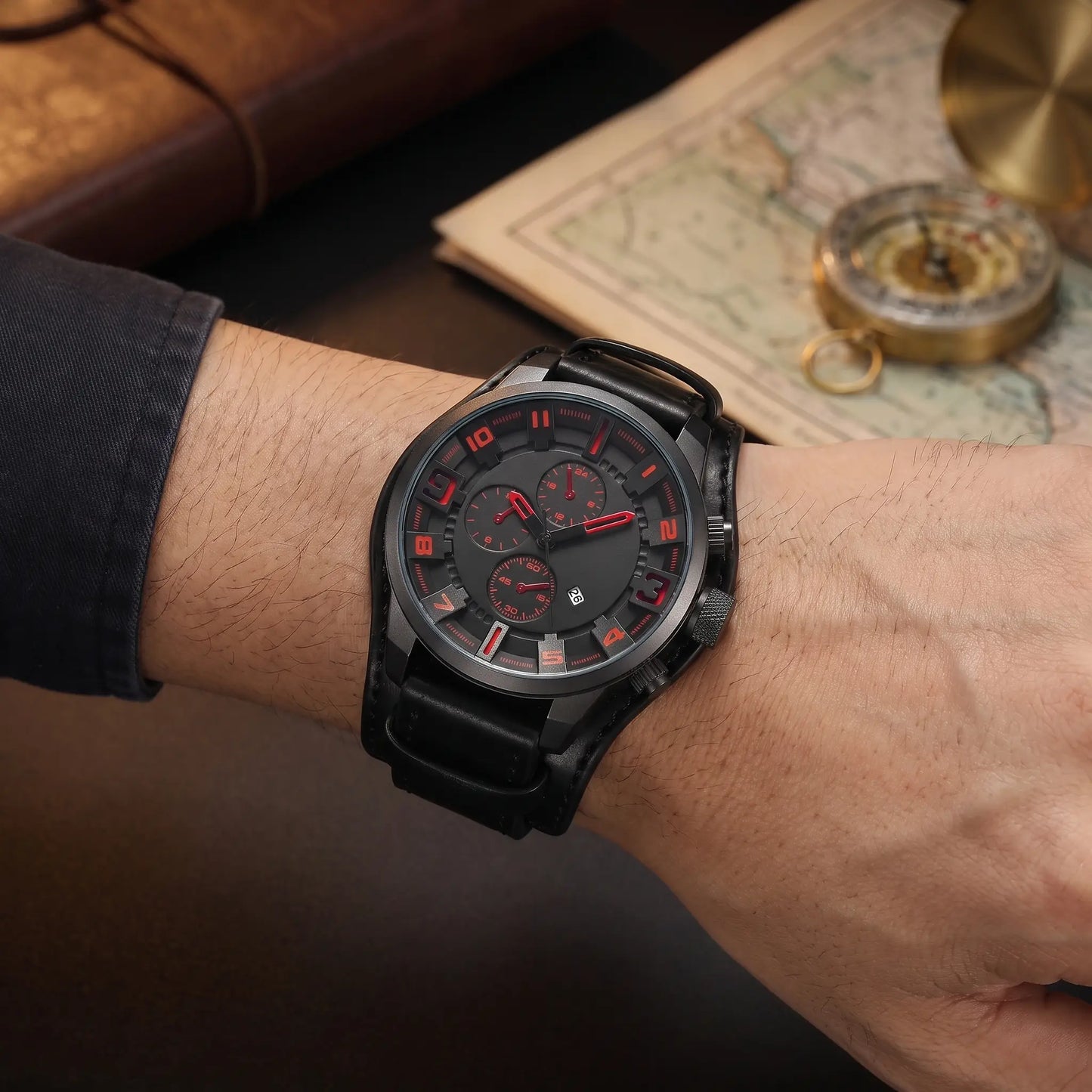 Man wearing the black and red Wide Cuff Watch with his forearms resting on a desk